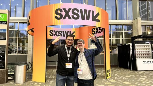 Picture of Alvin Graylin and Kent Bye standing in front of a SXSW sign flashing peace signs.