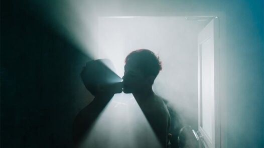 Two men kissing in a steam room back light with dramatic lighting