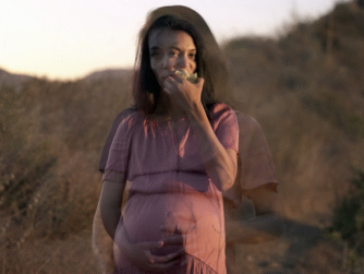 Double exposed picture of a pregnant woman standing in a field